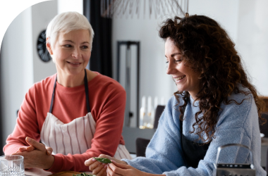 young female caregiver preparing a meal for an elderly woman in homemaker services