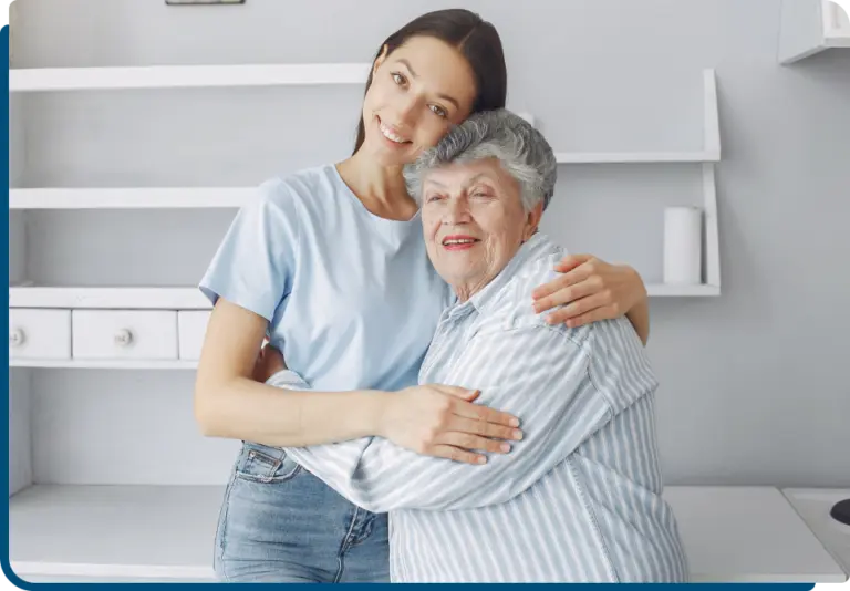 Caregiver cuddling elder and both are happy