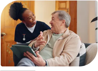 an old man smiling while holding caregiver's hand